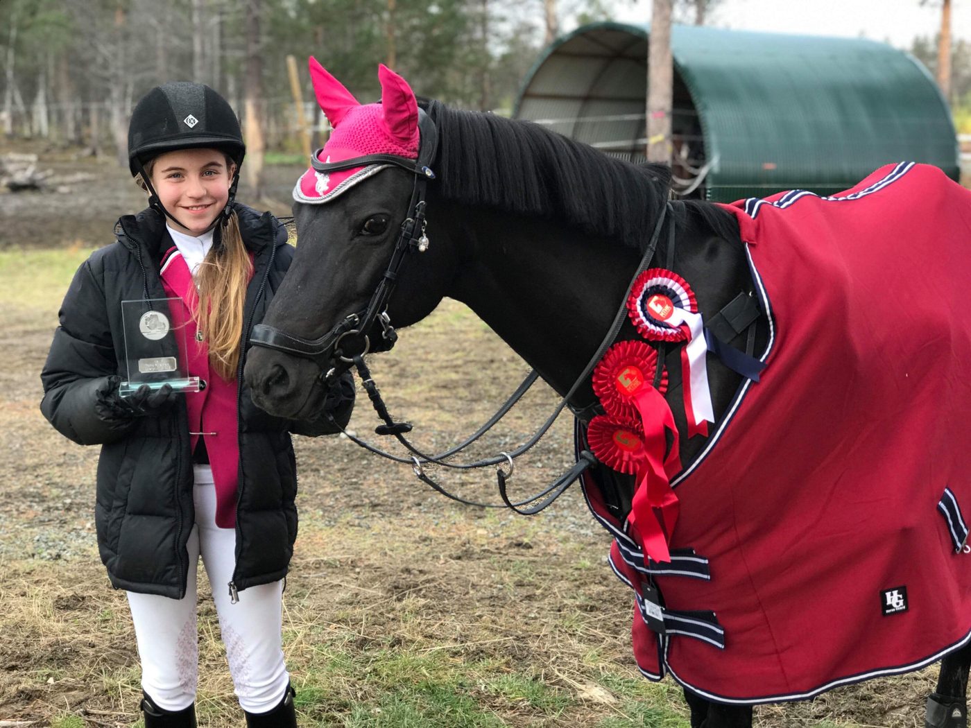 Bertine with her horse and award rosettes